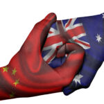 Diplomatic handshake between countries: flags of China and Australia overprinted the two hands